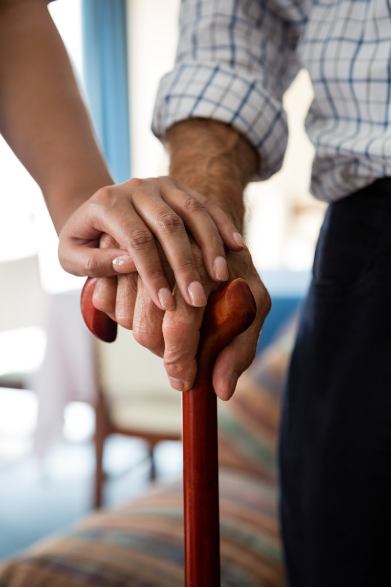 Hands of female doctor and senior man holding walking cane in retirement home personne agéee tenant une canne avec une perssonne jeune qui pose sa main sur lui